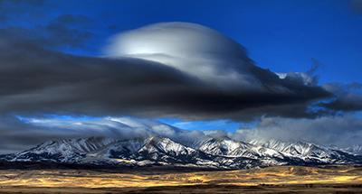 Лентикулярное облако образовалось над горами в штате Монтана, США. (James Woodcock, Billings Gazette via Associated Press)