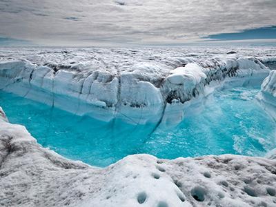 Талая вода бежит по траншее, вымытой в поверхности Гренландского ледяного щита, к юго-западу от Илулиссата, Гренландия. (Ian Joughin/Associated Press)